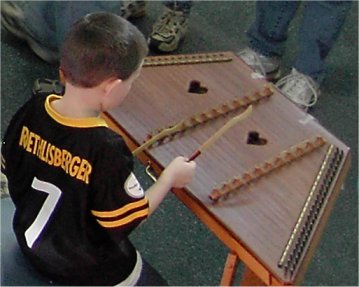 boy playing a hammered dulcimer