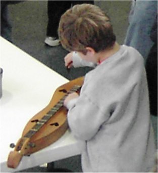 boy touching a lap dulcimer